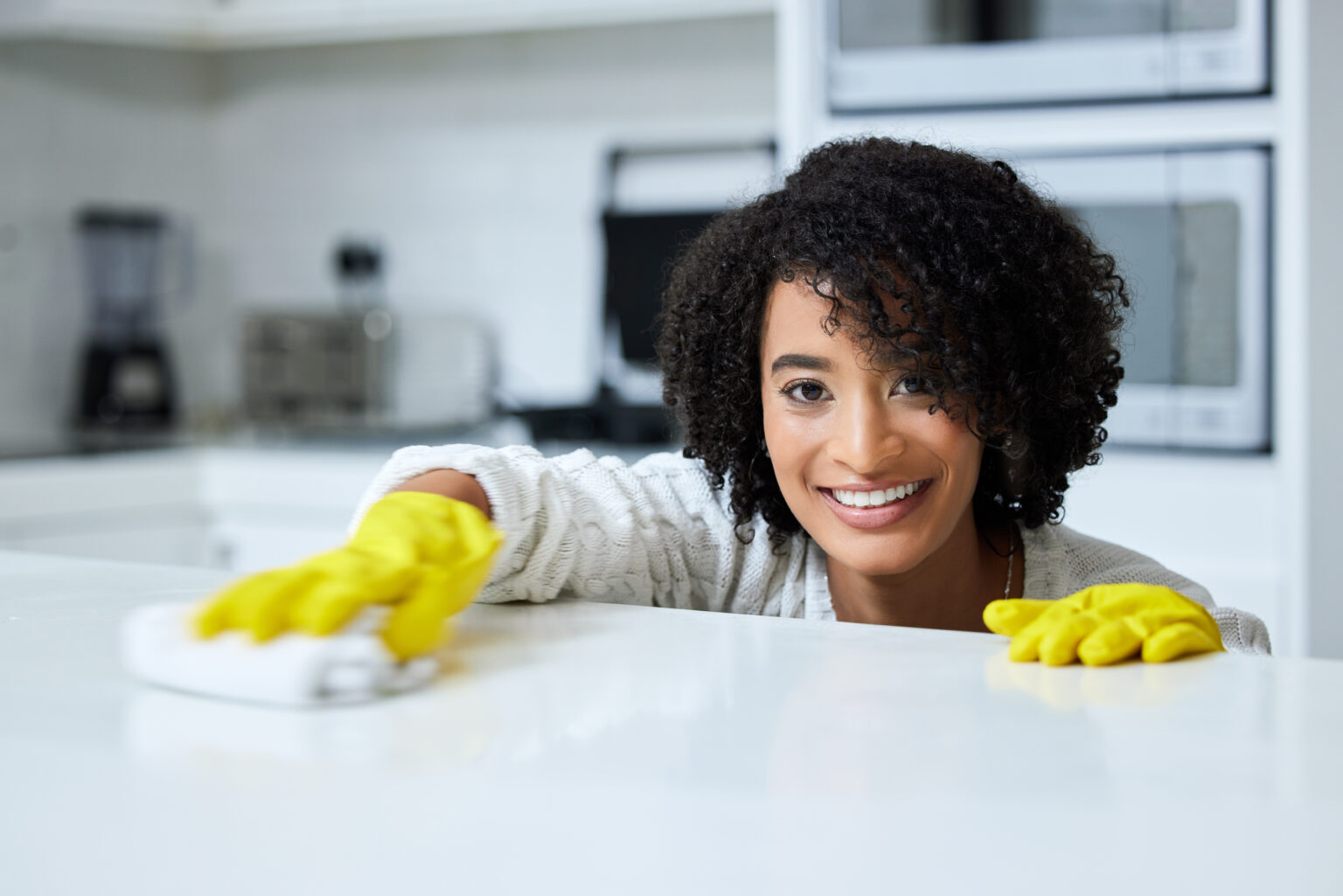 Shot Of A Young Woman Cleaning Her Kitchen Counter
